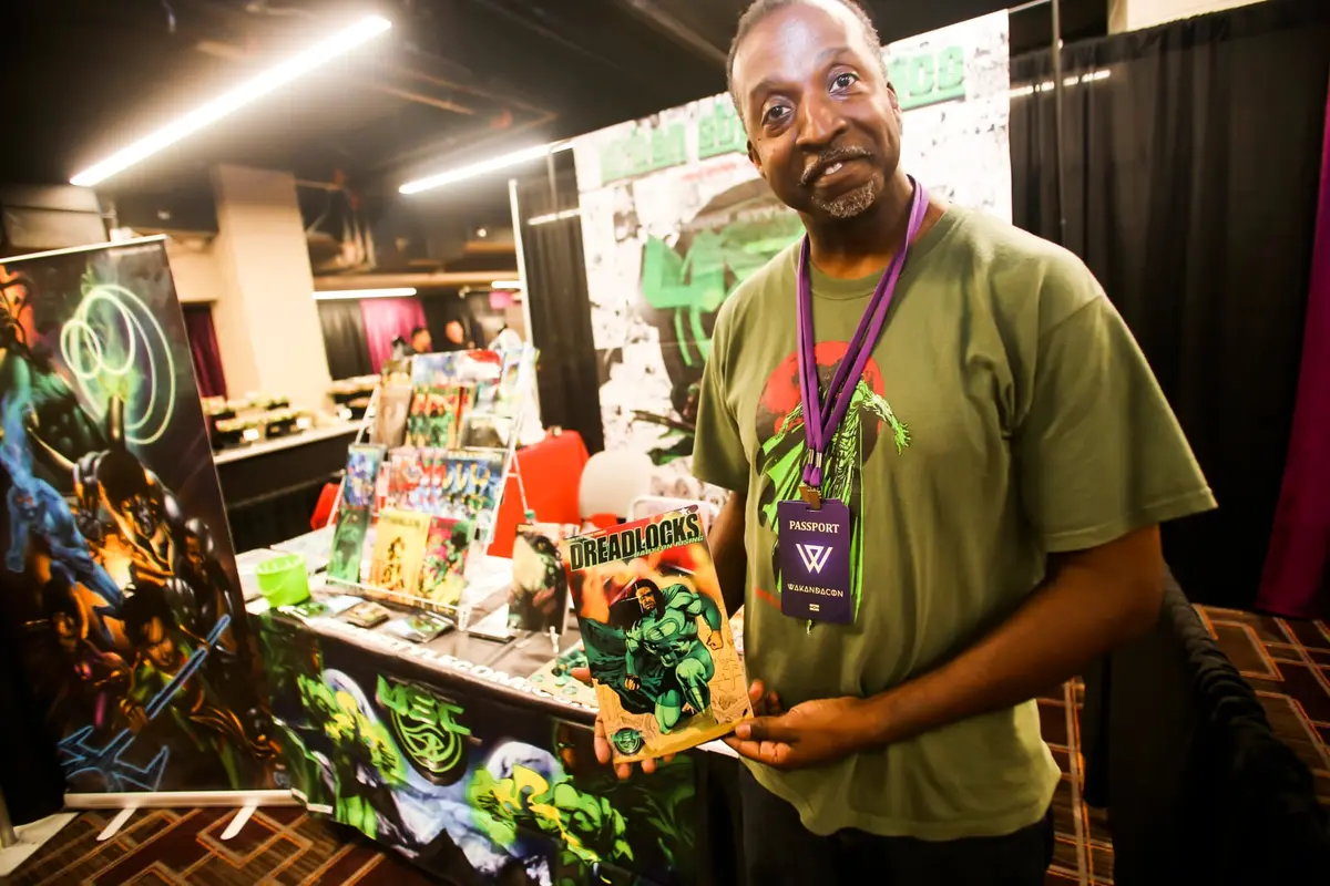 Shoppers browse tables of books, comics and art.