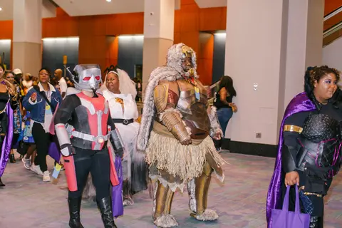 Cosplayers in armour and capes march through the concourse.